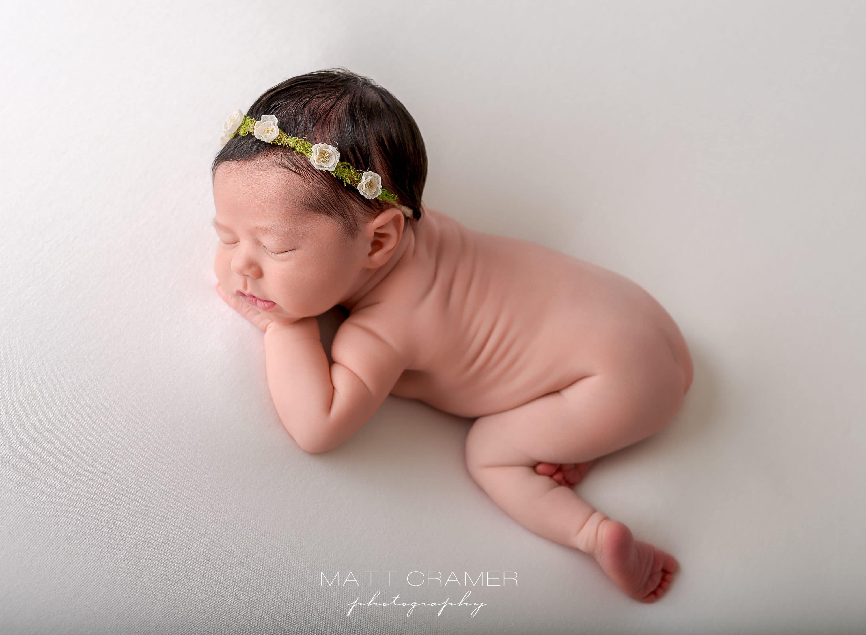 newborn infant with floral headband photographed during newborn session in Los angeles