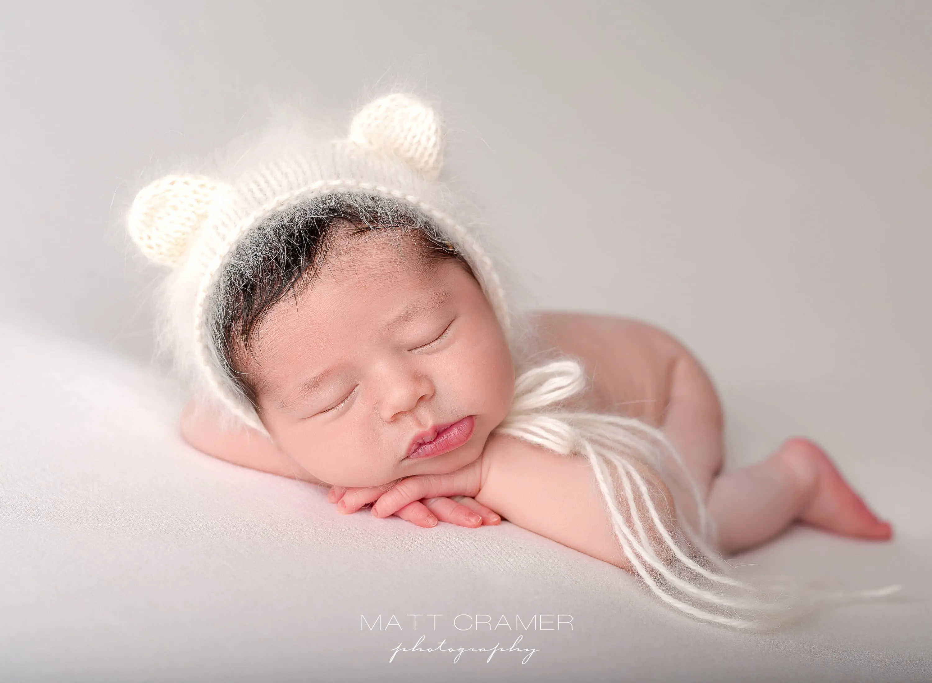 newborn baby wearing teddy bear hat