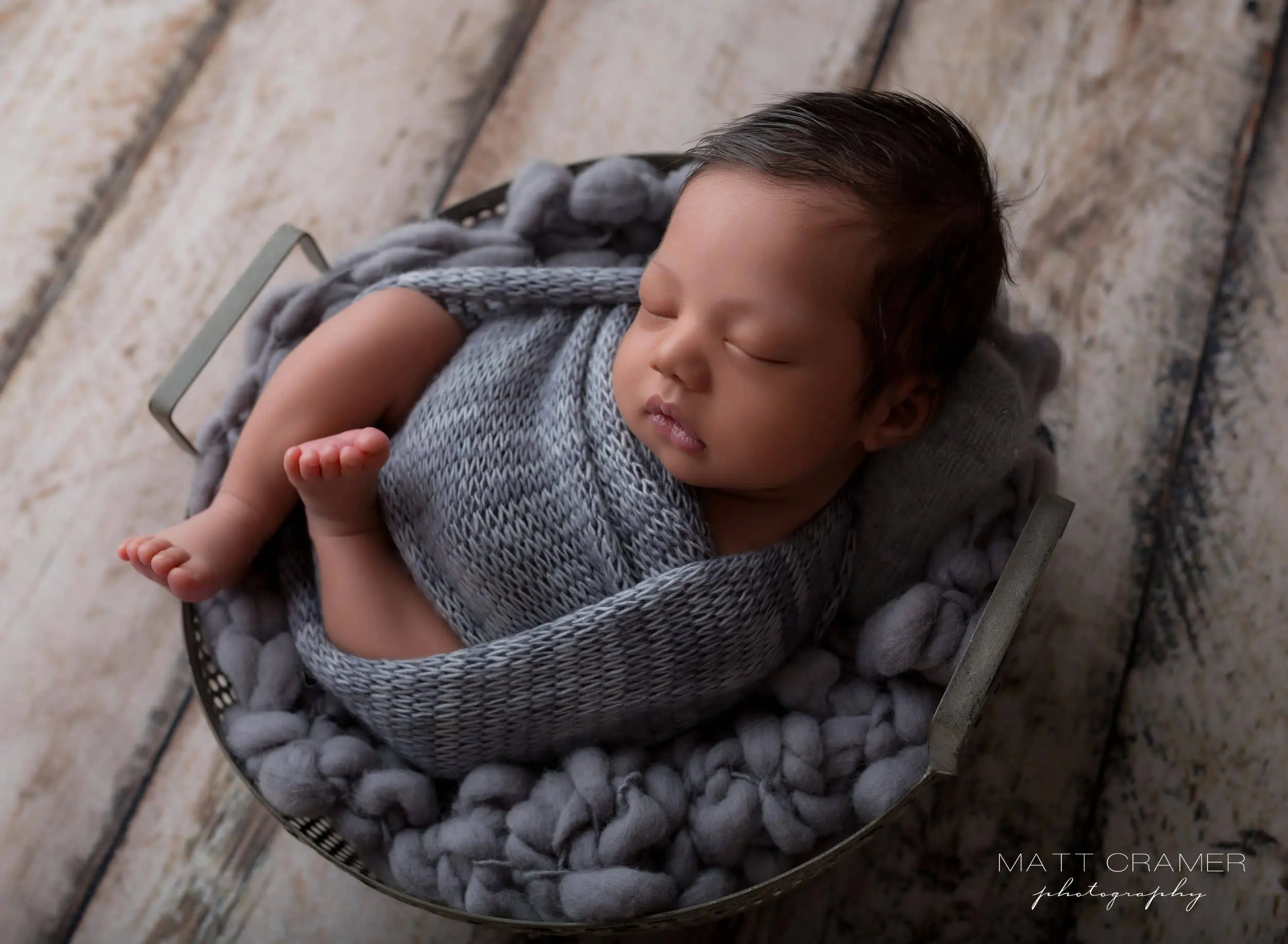 newborn baby boy in swaddle wrap during a photo shoot