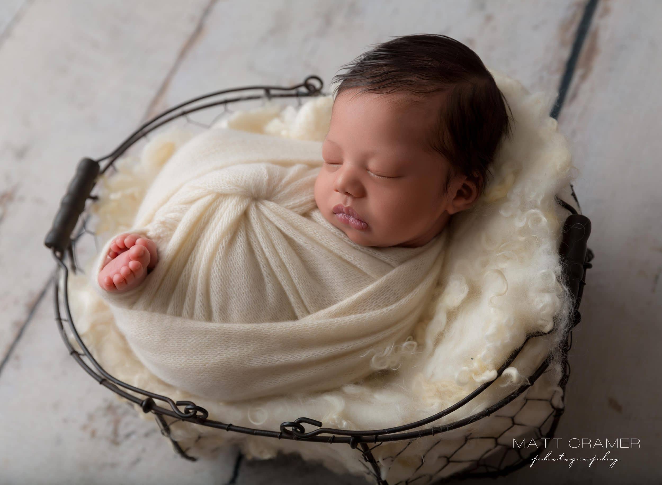 newborn baby boy in white swaddle wrap