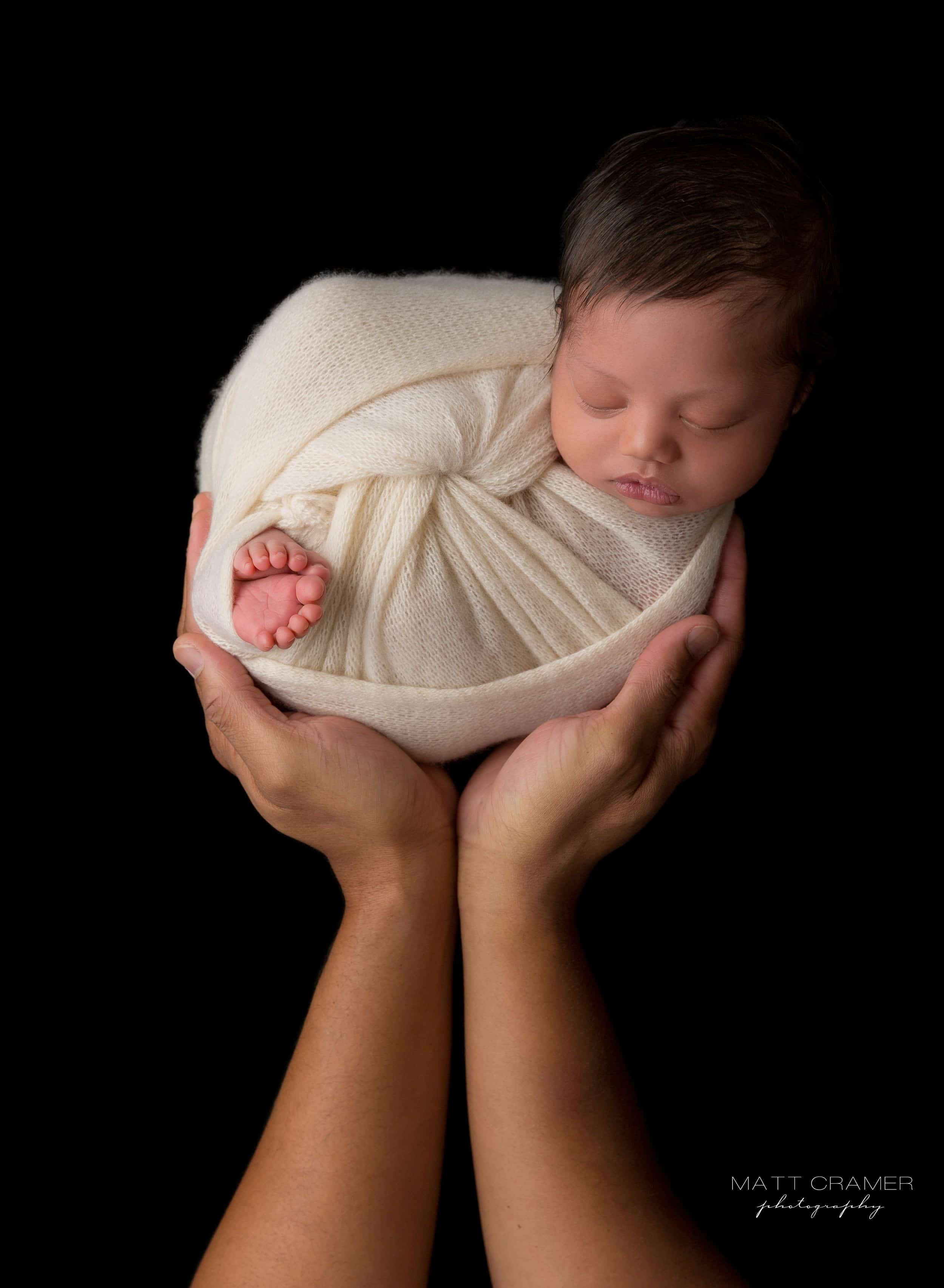 baby held in parent hands