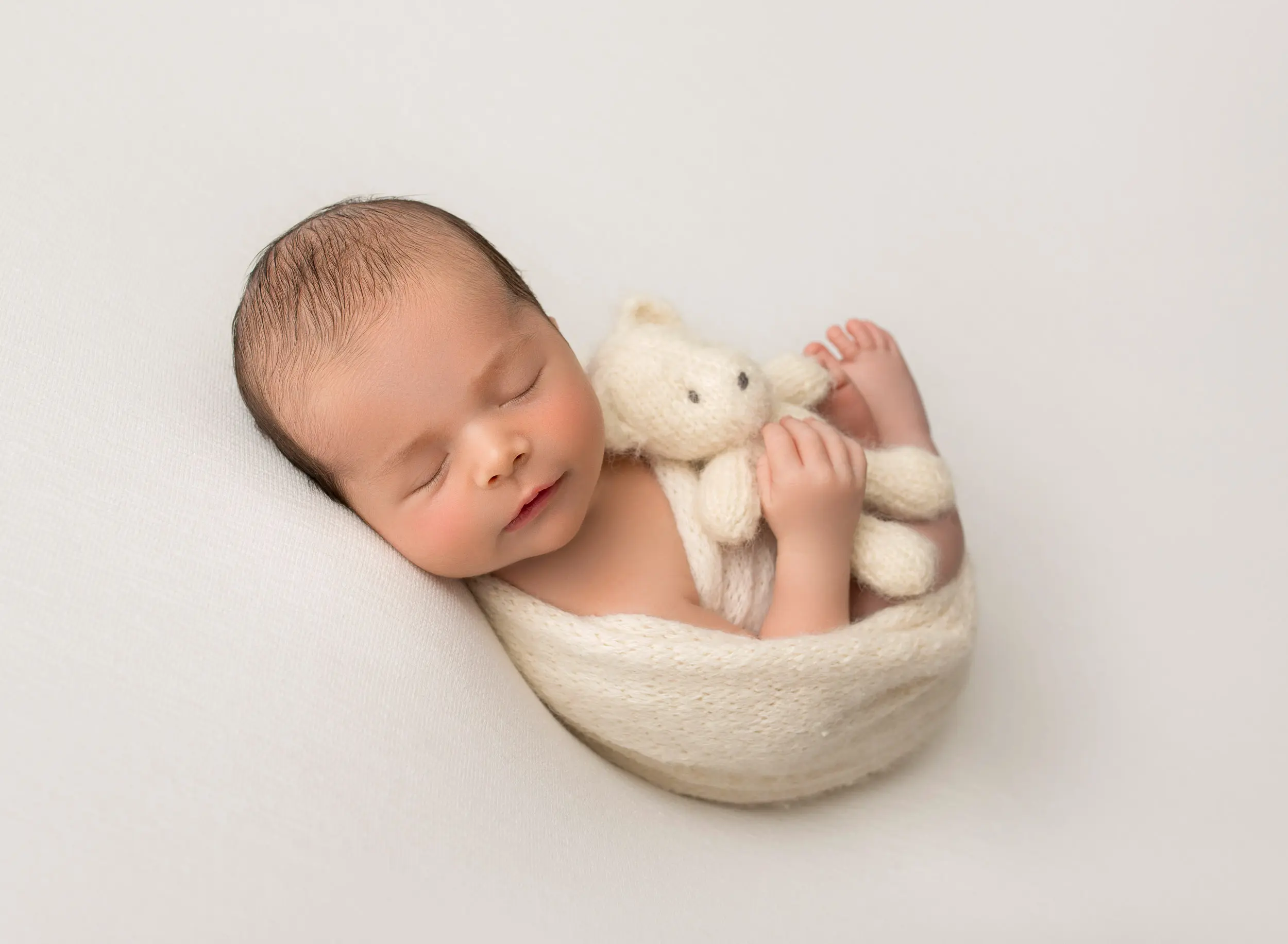 baby boy snuggling white teddy bear