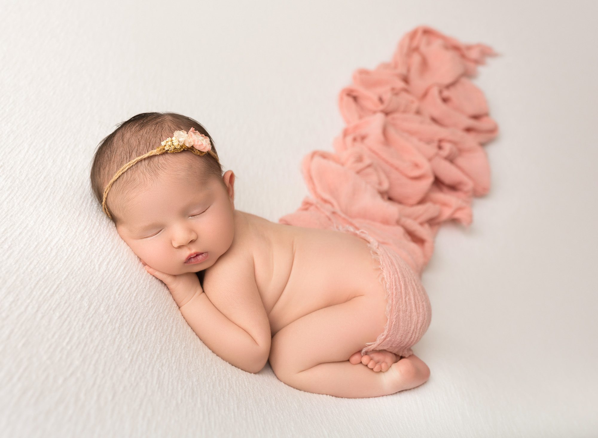 newborn baby girl with pink wrap trailing off