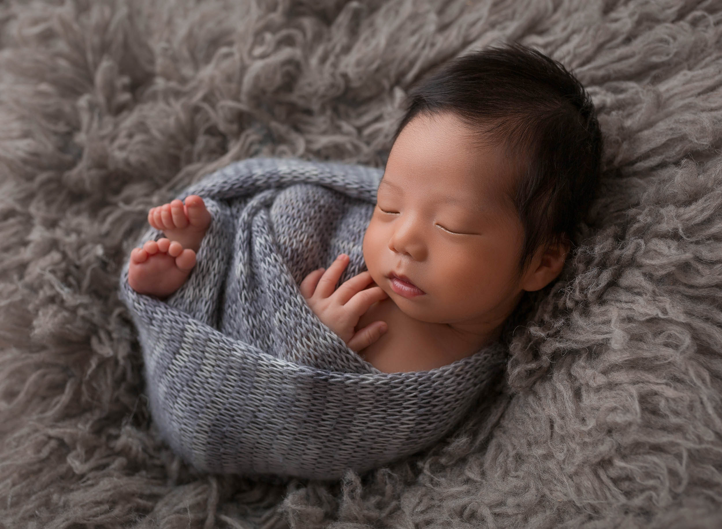 baby boy swaddled in blue wrap