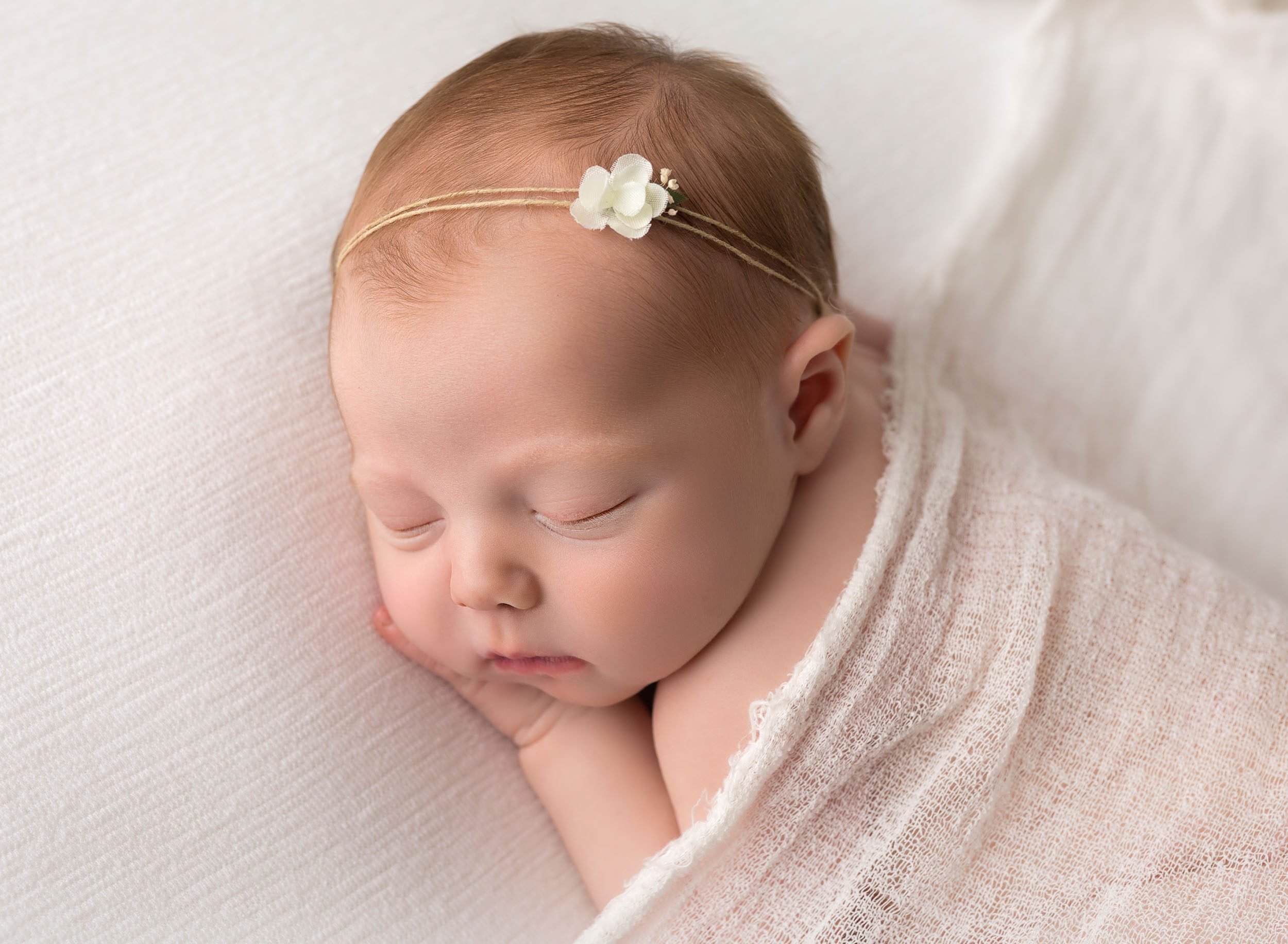 Newborn baby on white fabric
