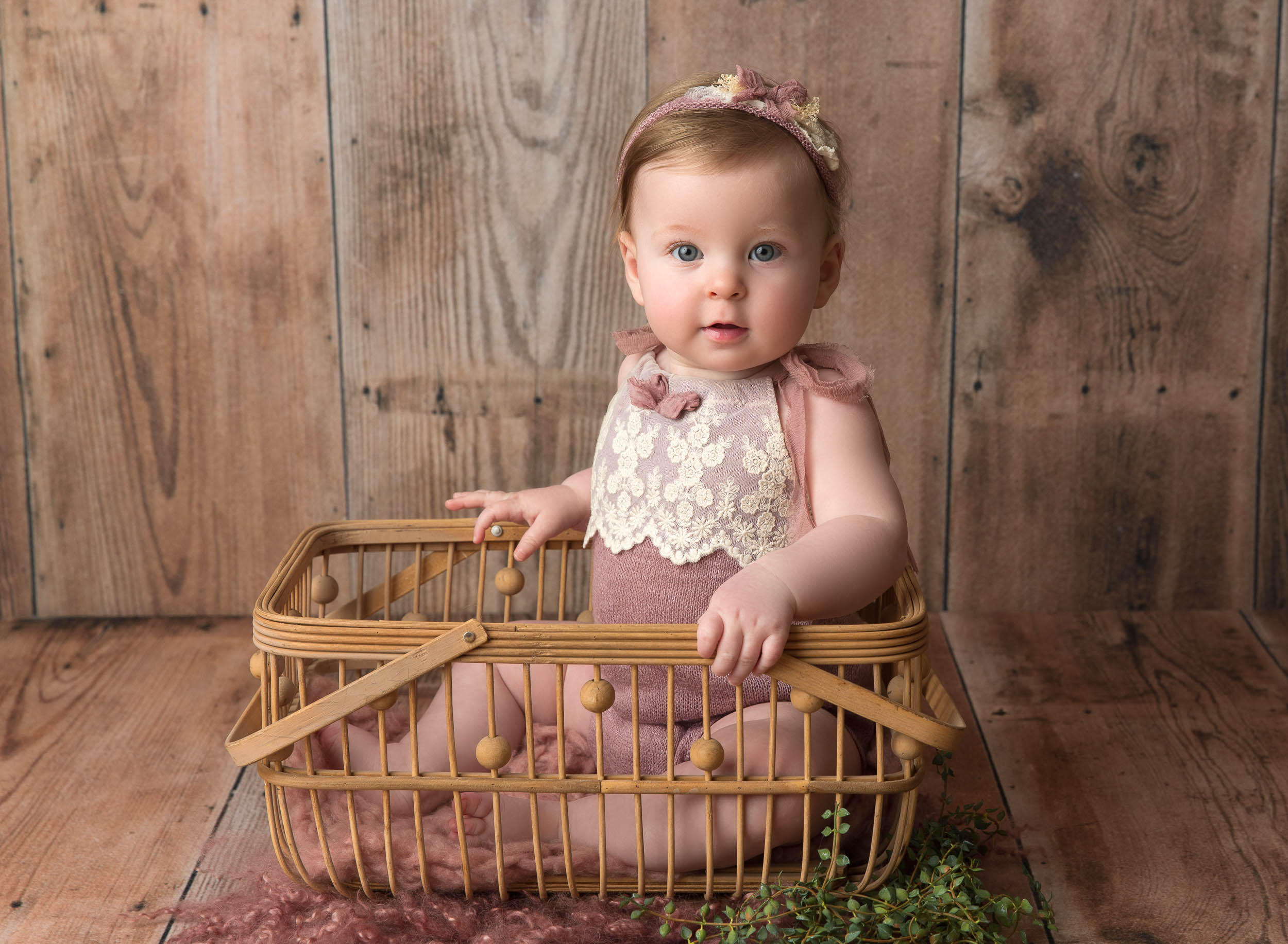 baby girl sitting in crate in lilac outfit and matching headband