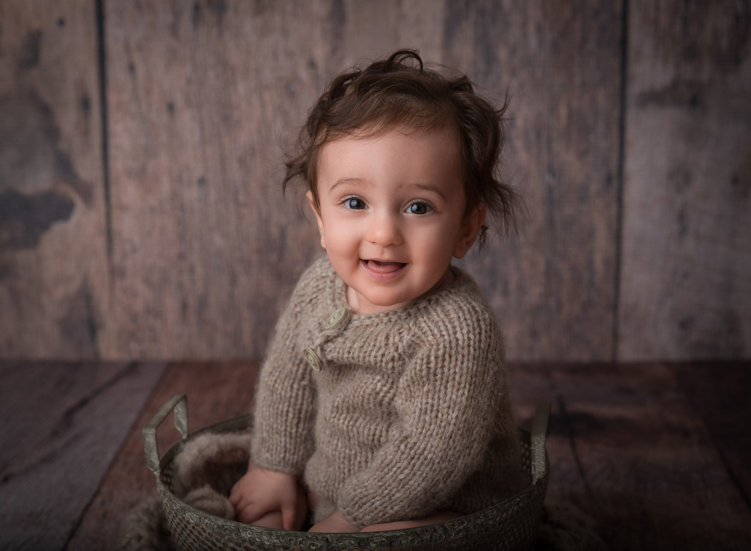 wild haired baby boy in knit outfit smiling
