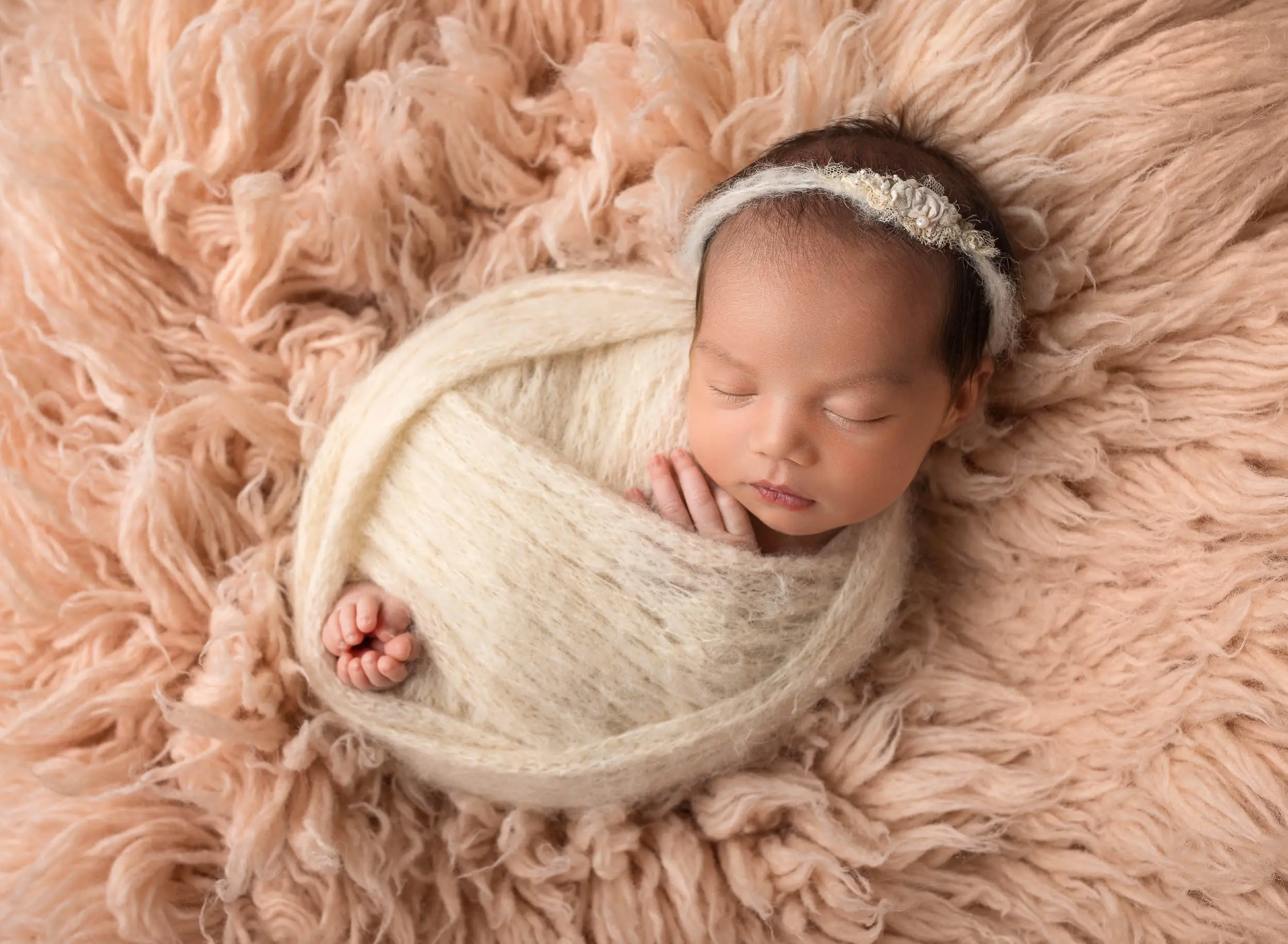 newborn baby girl laying on blush pink rug