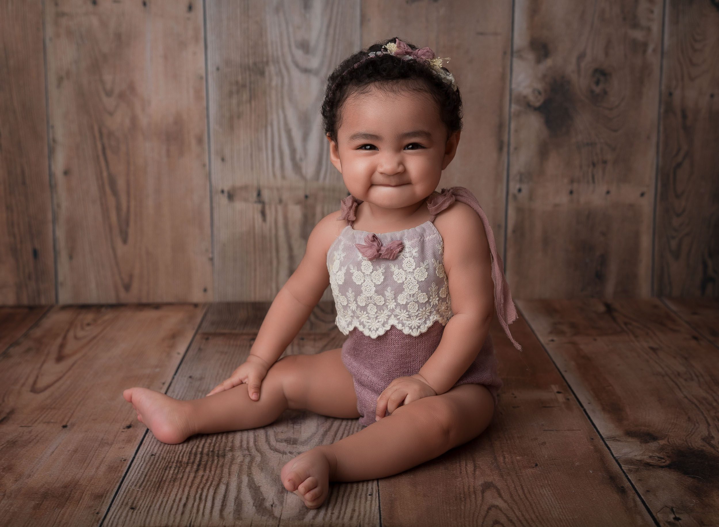 baby girl in photoshoot smiling in lilac outfit