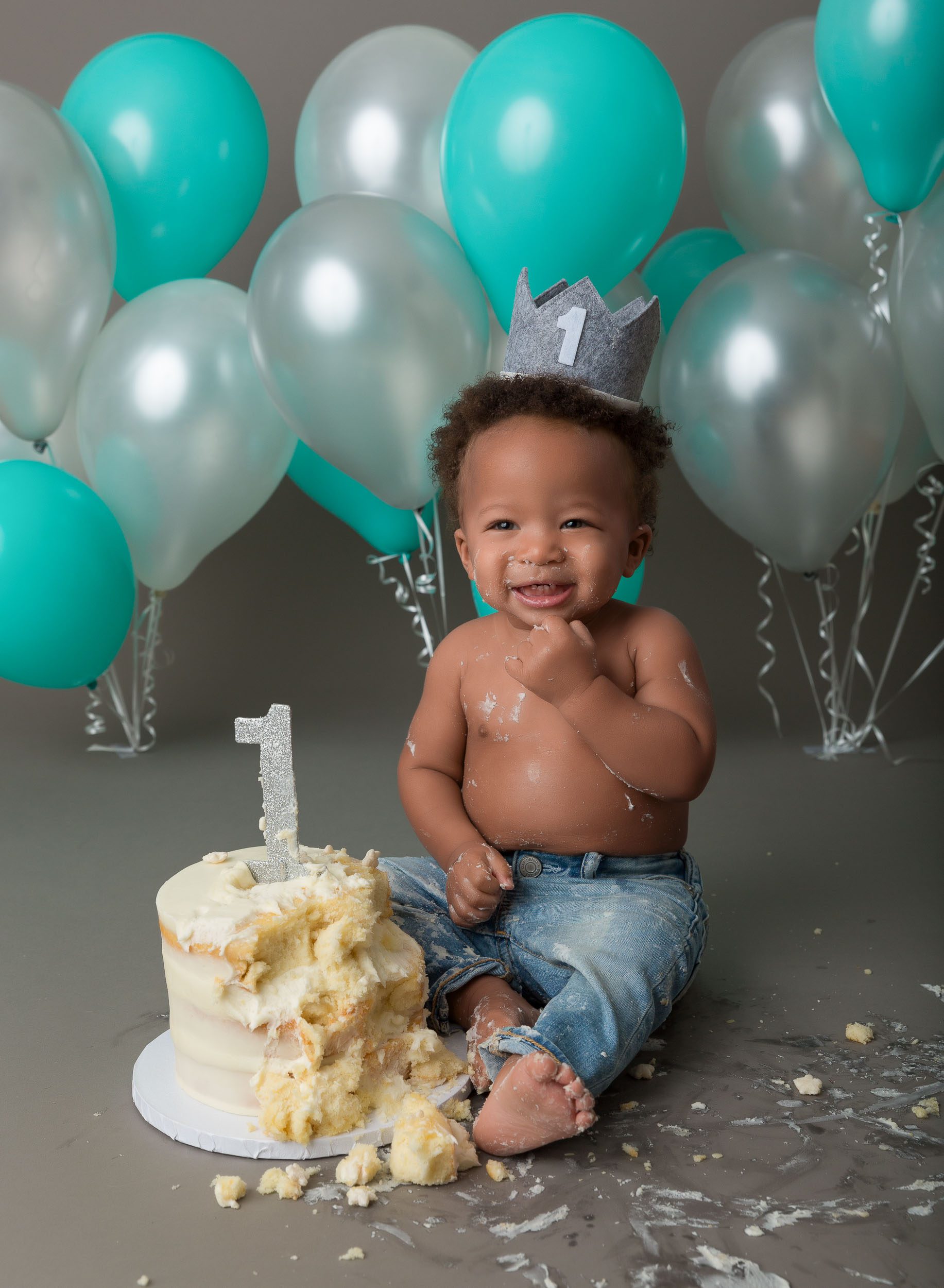 baby eating cake with balloons