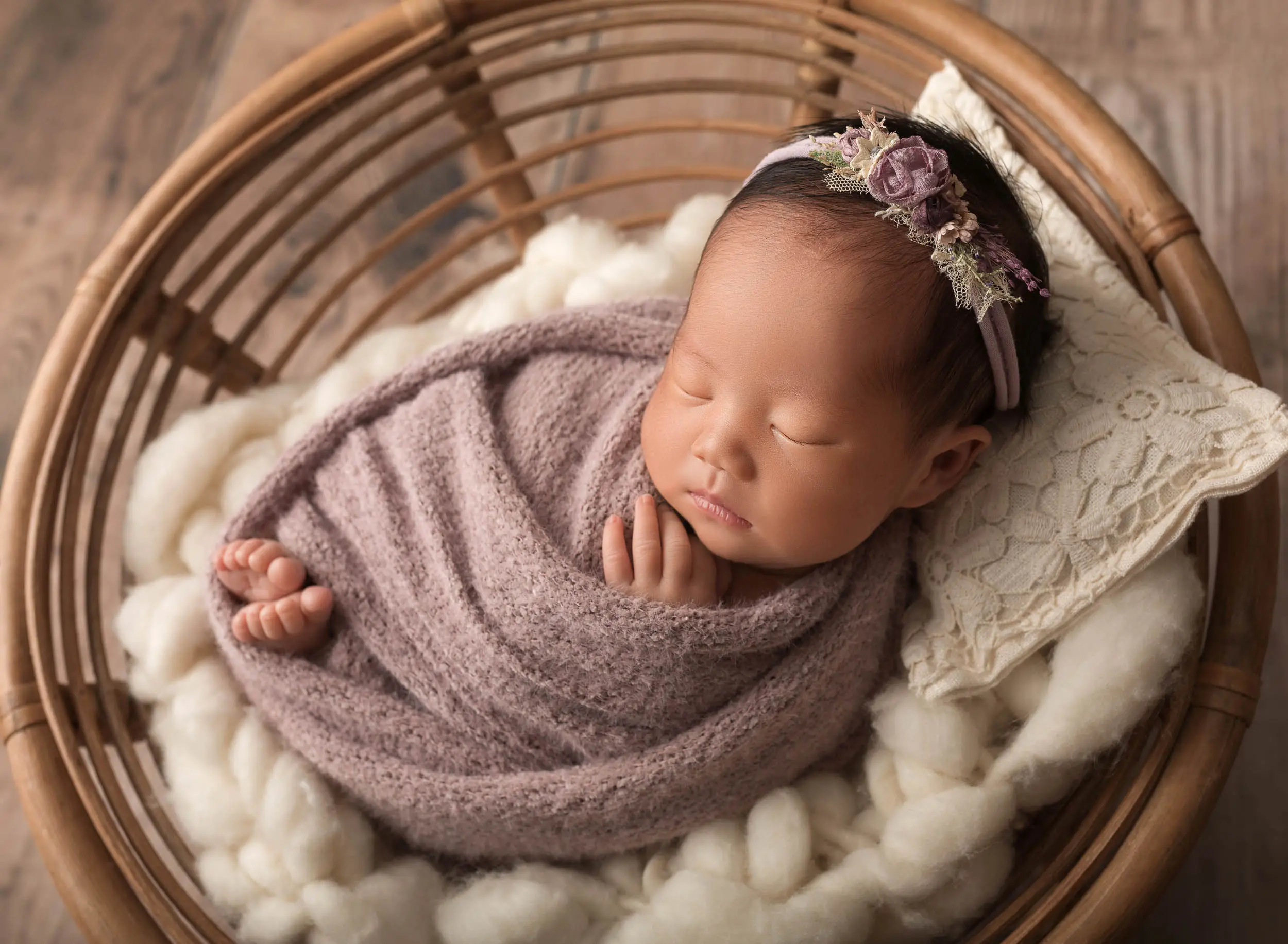 baby girl in lilac wrap and flower headband