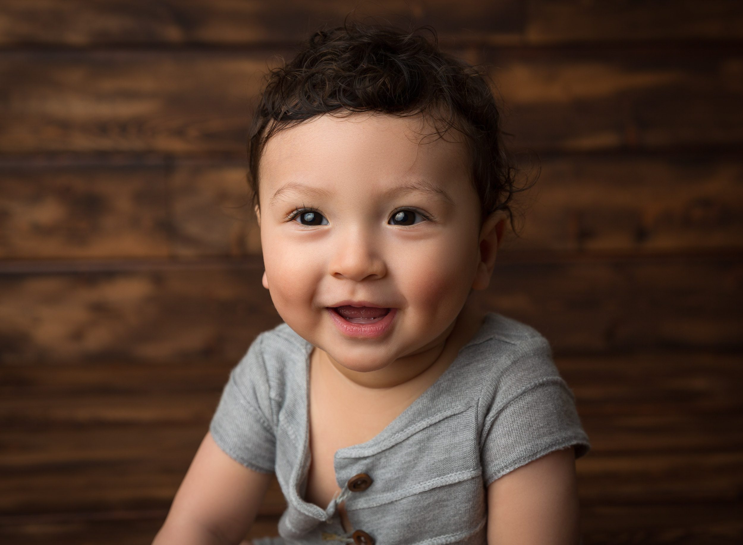 smiling baby boy in grey outfit